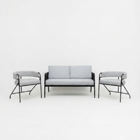 A modern three-piece living room furniture set consisting of a two-seater sofa and two matching armchairs with light gray fabric upholstery and black metal frames, set against a seamless white studio background.